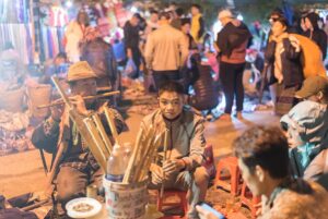 local man playing flute at the Love Market in Sapa