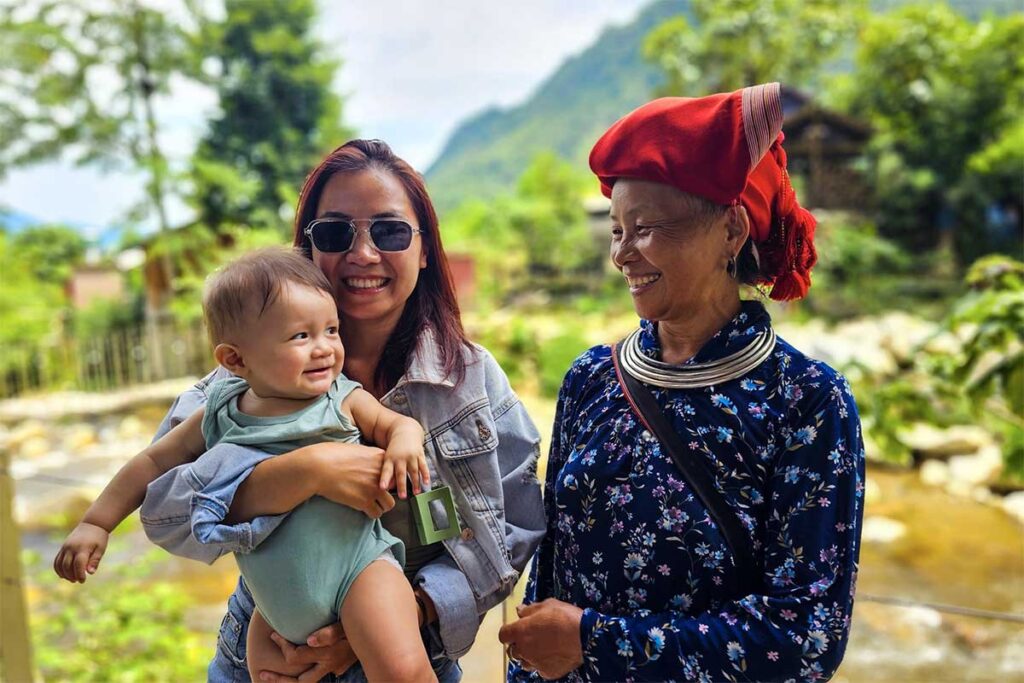 woman holding her baby next to a ethnic minority woman in traditional clothes in Sapa