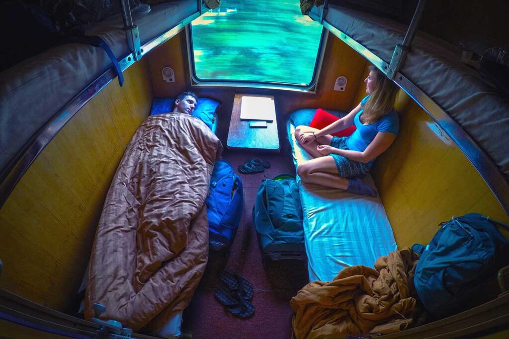 Couple in a 4-berth sleeper train cabin in Vietnam – travel tip for booking all beds for more privacy