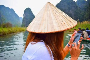 Female tourist is using apps on her phone while traveling in Vietnam