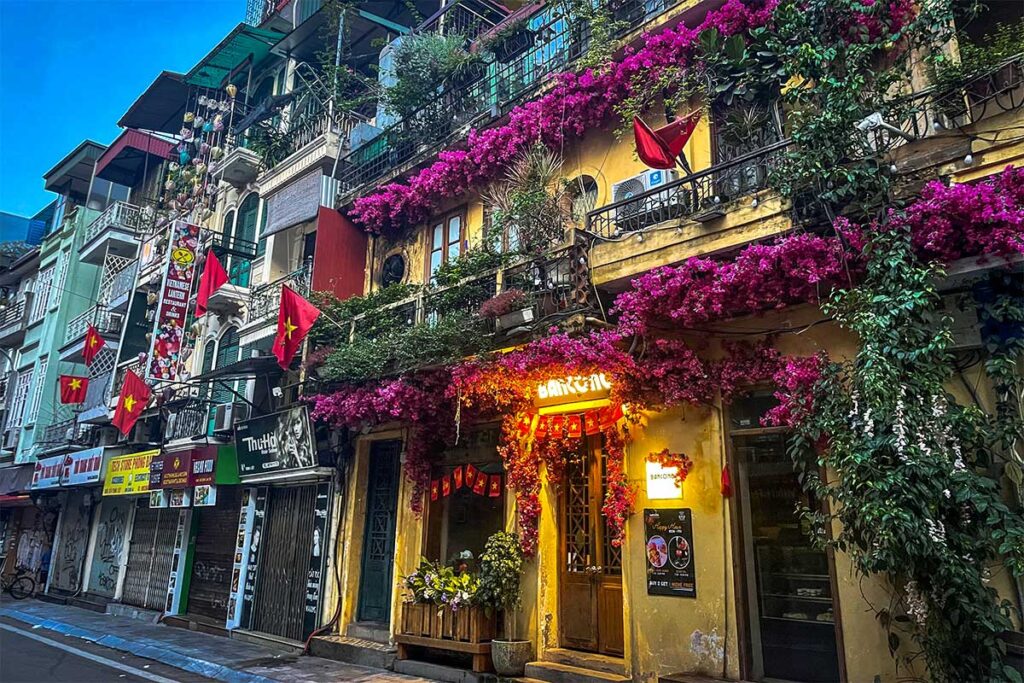 The beautiful outside with yellow walls and pink flowers of Bancong Café And Restaurant in Hanoi