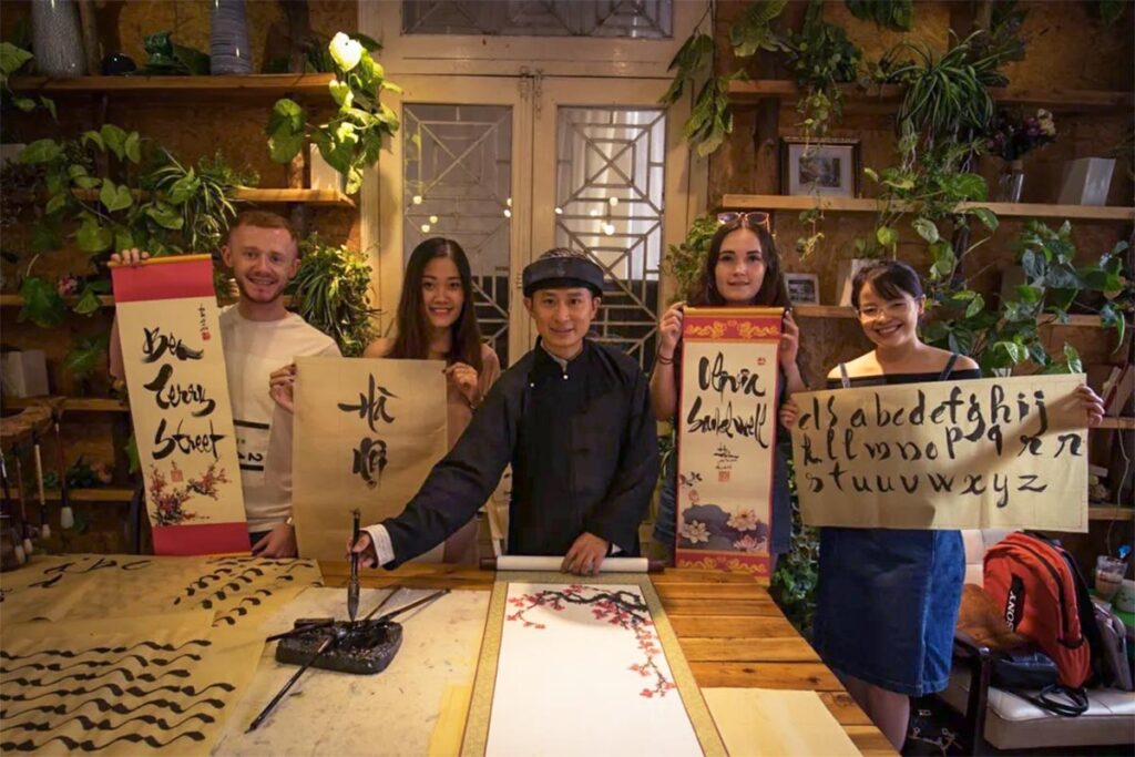 Tourists doing a unique experience in Hanoi at a calligraphy class