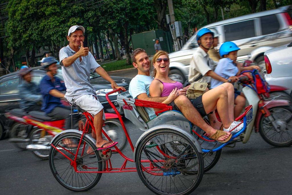 A couple sitting together in a cyclo going through Hanoi