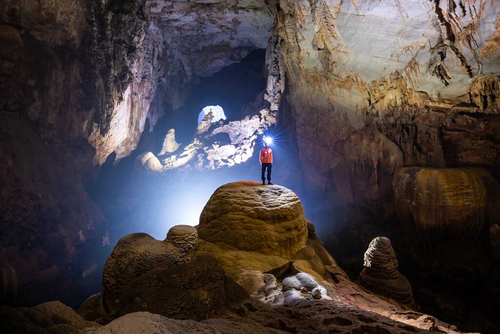 A man standing in the dark inside Hang Son Doong Cave