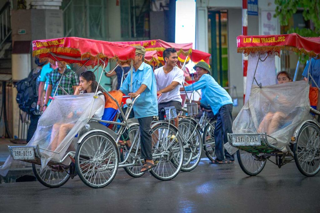 Traditional cyclo with rain covers for tourists during the rain in Hanoi