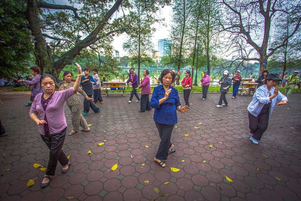 Hanoi in the morning at Hoan Kiem Lake - A group of local woman are doing tai chi next to the lake