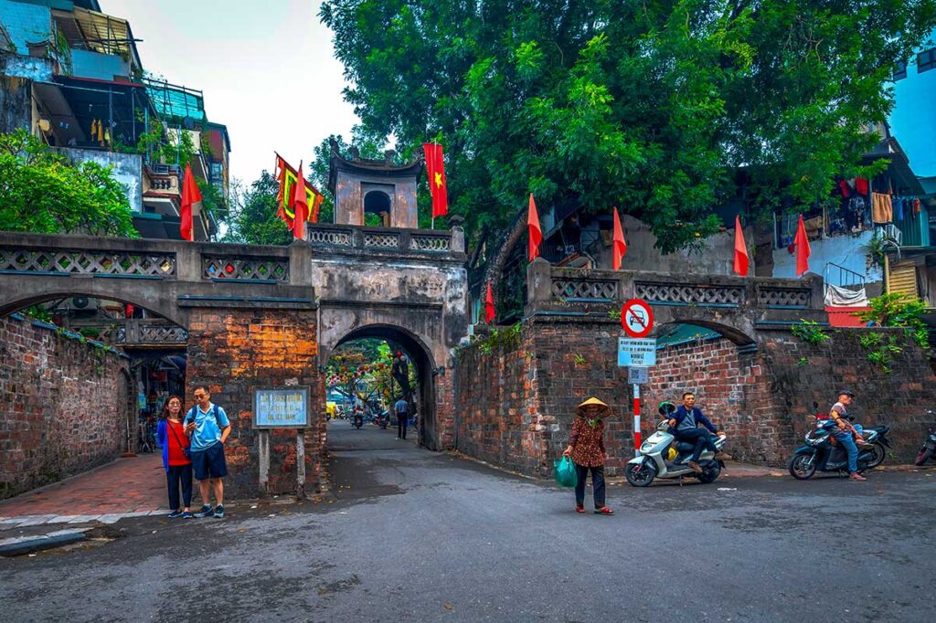 Tourists walking out of the left entrance of O Quan Chuong Gate in Hanoi