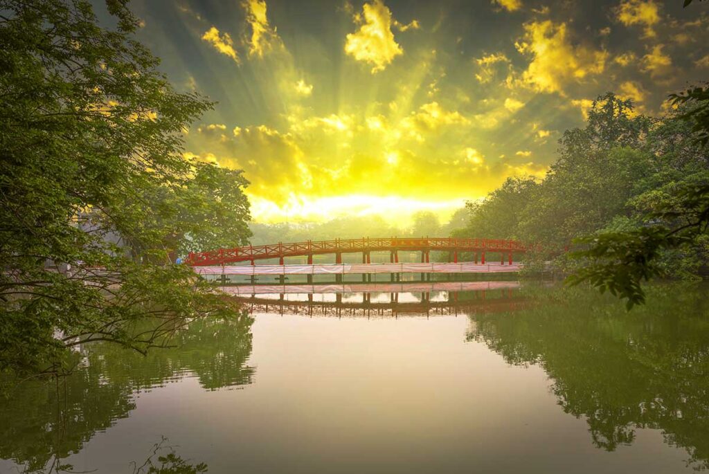 Hanoi sunrise at Hoan Kiem Lake with the golden light of the red Huc Bridge