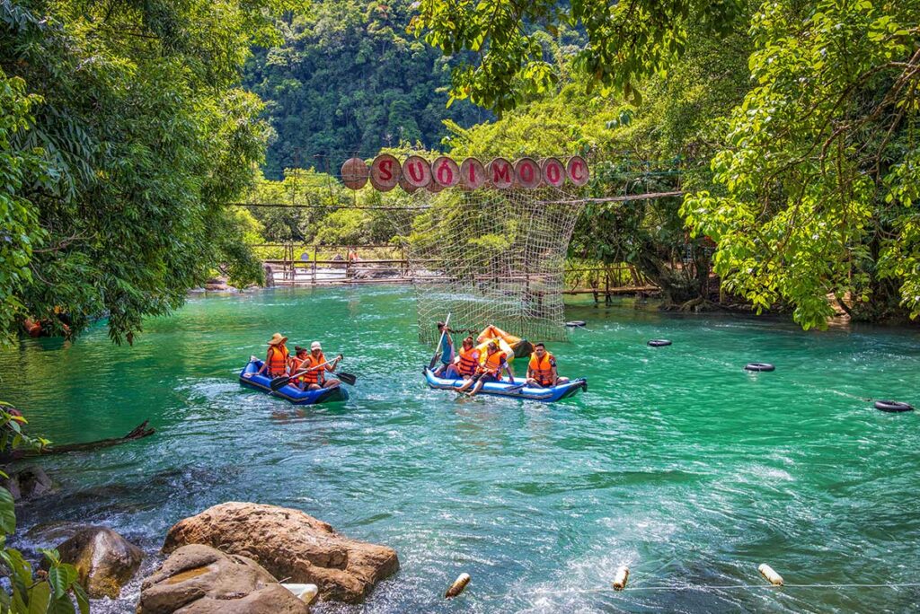 People kayaking in the clear water surounded by jungle at the Mooc Spring 