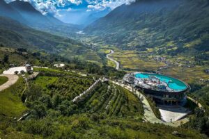 A view over Muong Hoa Valley in Sapa with on the for ground a resort with pool on the rooftop