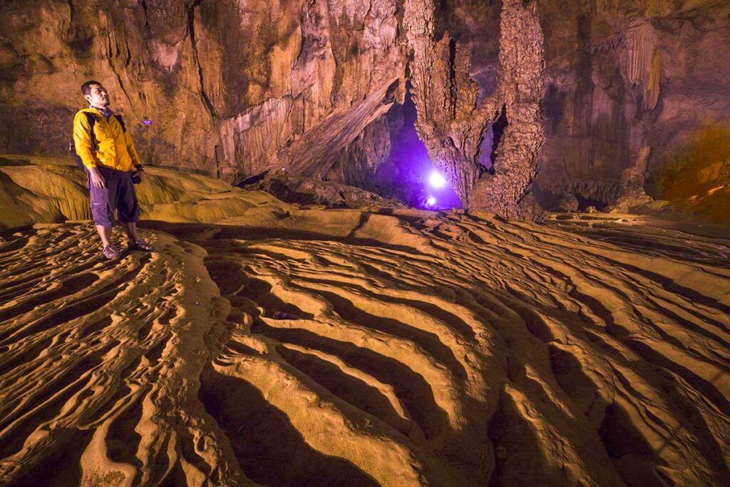 A man standing in Nguom Ngao Cave located near Ban Gioc Waterfall in Cao Bang