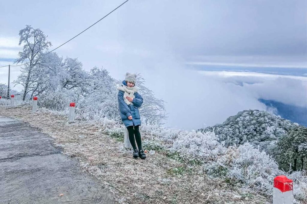 A girl standing in a frosted snowy landscape at Phia Oac National Park