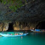 Two boats going through the entrance of Phong Nha Cave