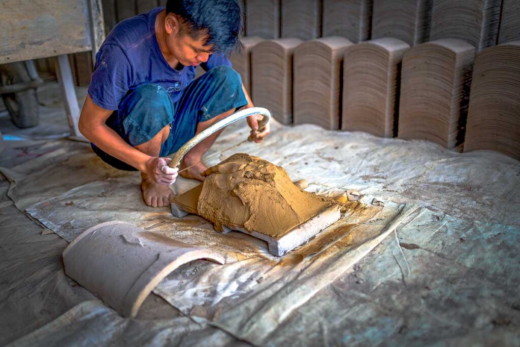 A man using clay to make roof tiles in Quynh Son Village in Bac Son Valley