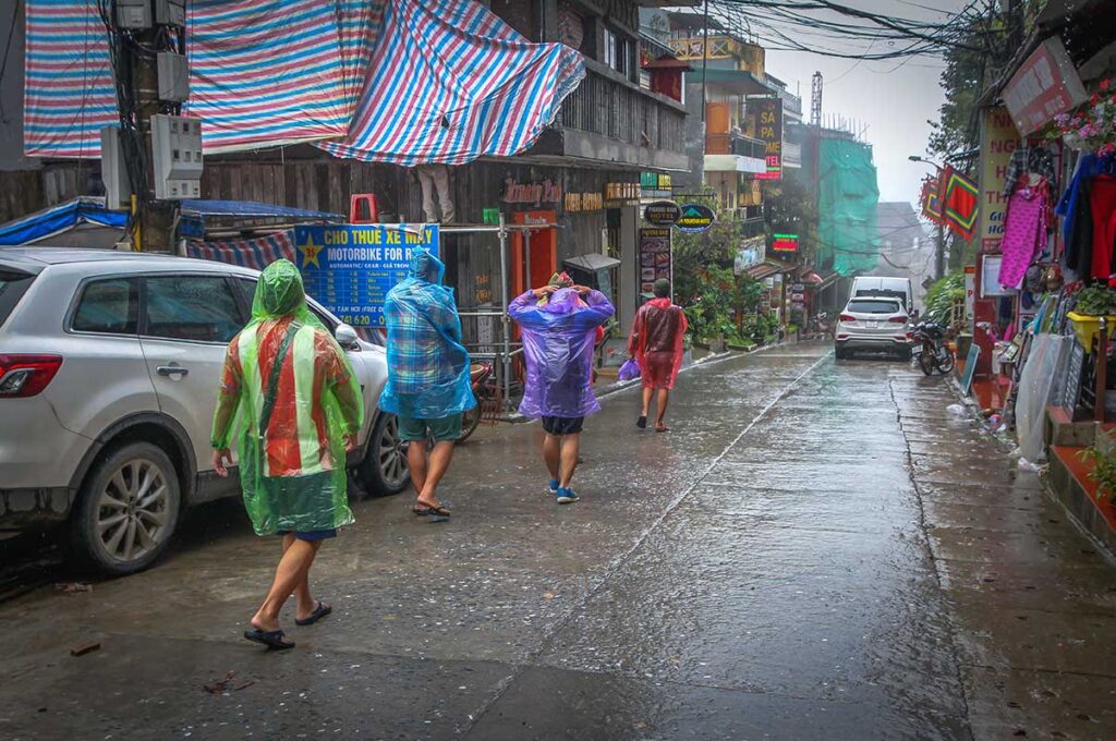 A group of tourist walking in the rain in Sapa wearing plastic rain ponchos