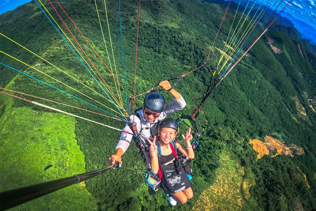 Tandem paragliding flight over forest near Hanoi