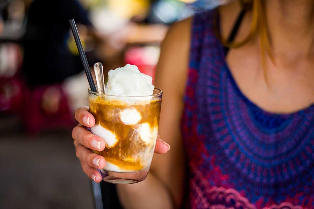 A woman holding a Vietnamese coconut coffee