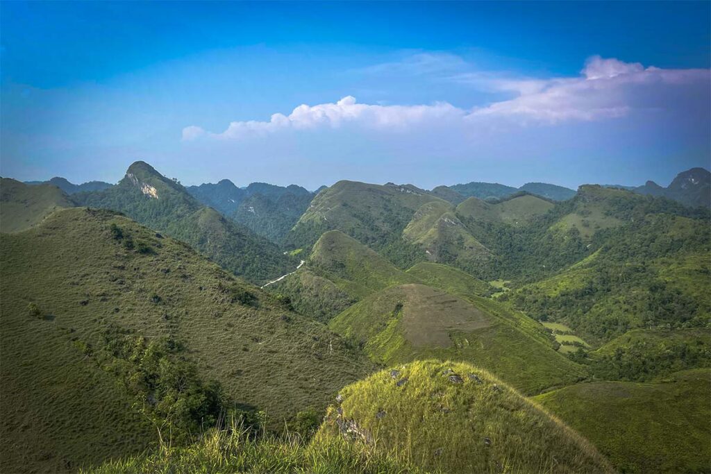 Beautiful green grass hills during rainy season at Vinh Quy Grass Hill in Cao Bang