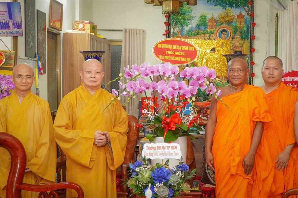 Buddhist monks in Vietnam celebrating Chol Chnam Thmay, the Khmer New Year festival, with flower offerings and prayers inside a decorated temple.
