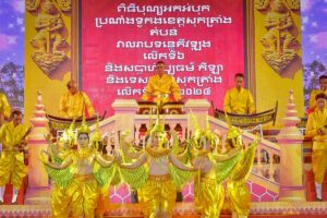 Khmer New Year celebrations in Vietnam with golden-costumed dancers and musicians performing on stage during Chol Chnam Thmay festival.