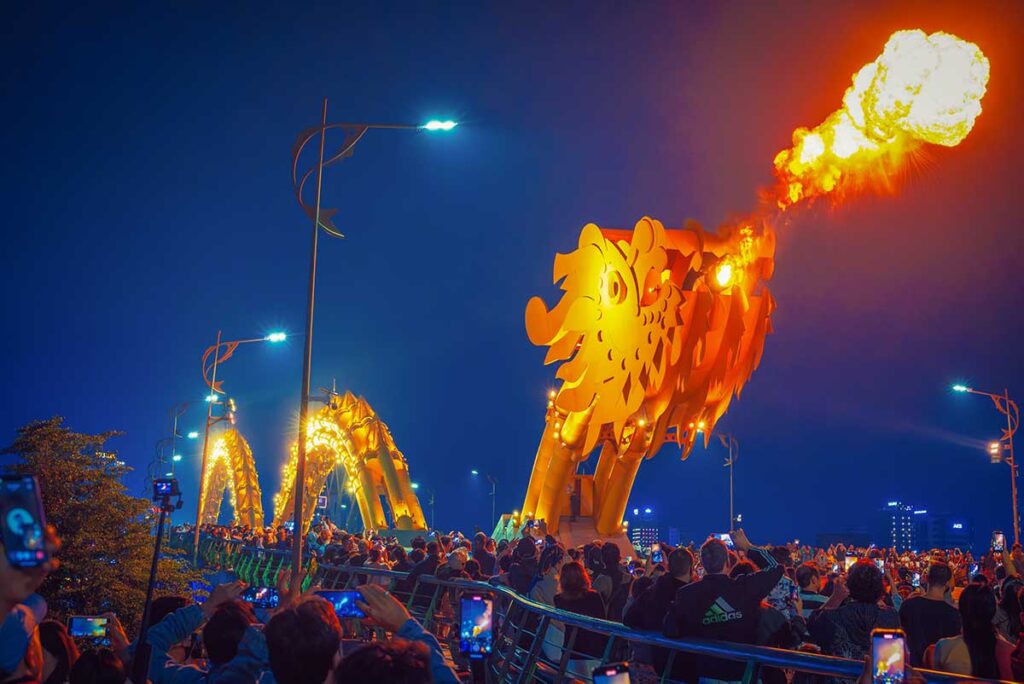 Crowds watching the Dragon Bridge fire and water show in Da Nang – a popular evening day trip from Hoi An.