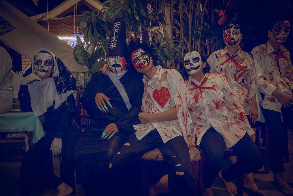 Group of young people dressed in Halloween costumes and face paint at a Halloween party in Vietnam.