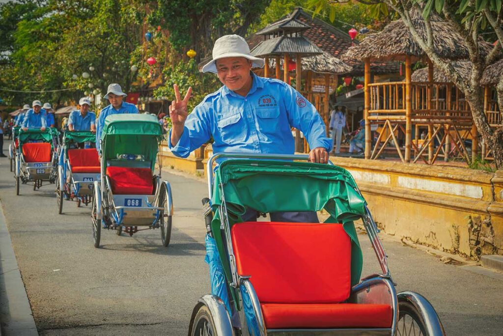 Smiling cyclo driver giving a peace sign – a classic and relaxing way to get around Hoi An Ancient Town.