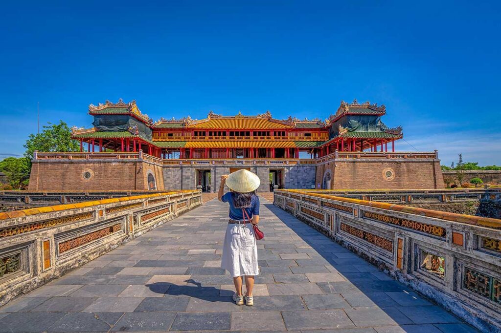 A tourist standing in from of the main gate of the Imperial City - one of the best things to do in Hue according to most Hue travel guides