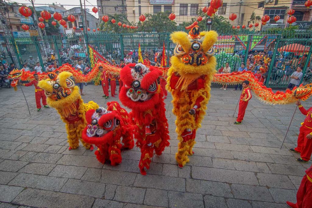 Vietnamese lion dance performed in front of a temple during a religious or cultural celebration.