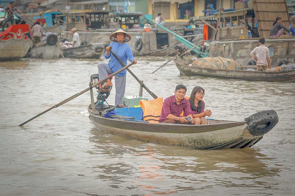 Couple taking a boat trip through the Mekong Delta, a relaxed and intimate experience in southern Vietnam.
