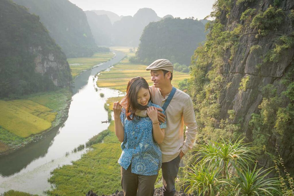 Couple enjoying a romantic moment overlooking the river and limestone landscape in Ninh Binh, Vietnam.
