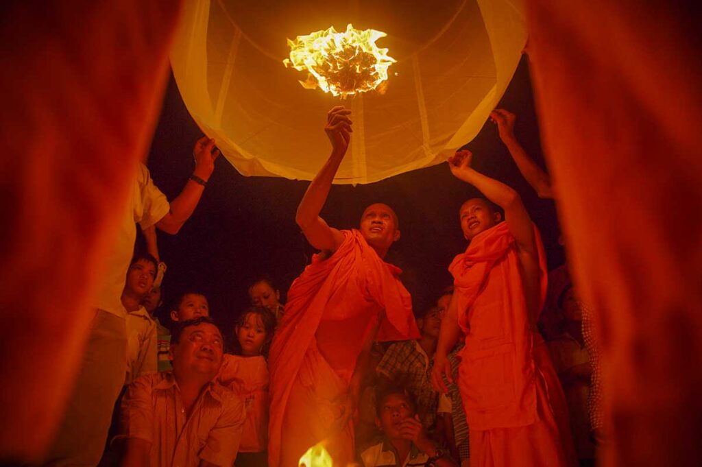Monks and villagers launching a sky lantern at night during the Ok Om Bok Festival in Tra Vinh, one of the most vibrant Khmer New Year celebrations in the Mekong Delta.