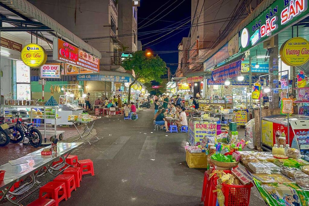 Bustling Quy Nhon night market with food stalls, seafood restaurants, and local specialties like bánh xèo tôm nhảy and bún chả cá.