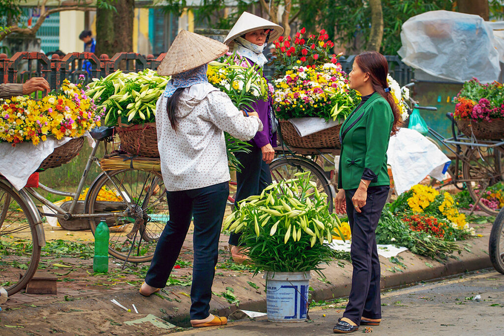 Street flower vendors in Vietnam selling fresh bouquets ahead of Vietnamese Women’s Day celebrations.