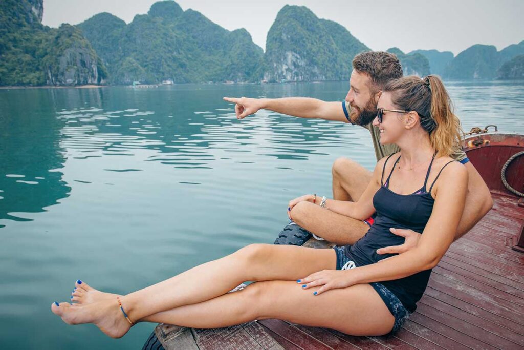 Couple relaxing on a boat in Halong Bay, enjoying one of Vietnam’s most romantic travel experiences.