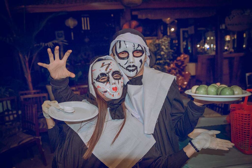 Group of people wearing Halloween costumes at an indoor Halloween party in Vietnam.