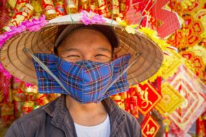 Vietnamese man wearing a face mask in a market showing common everyday use for dust and pollution protection