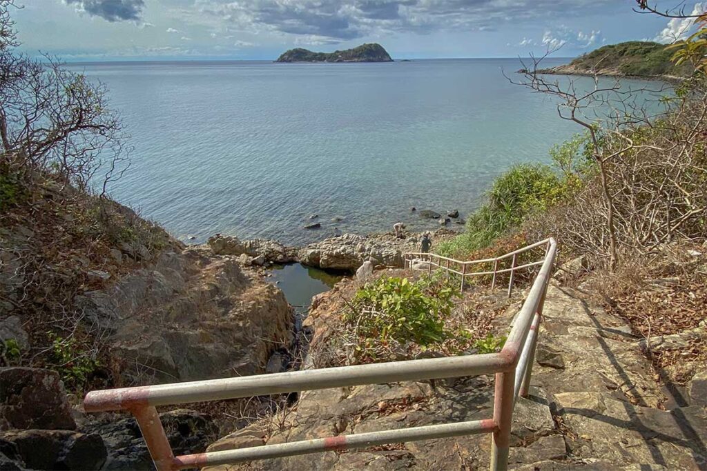Steep stone staircase descending toward a rocky coastal inlet at Bai Bang Beach in Con Dao National Park, with ocean views and small offshore islands