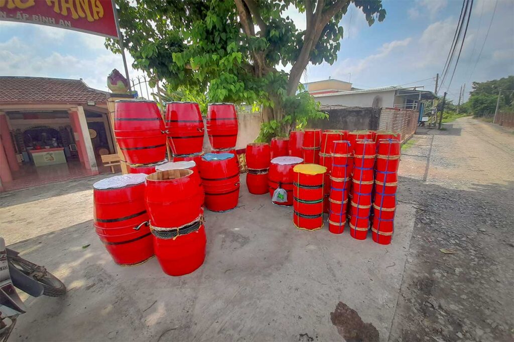 Rows of bright red ceremonial drums displayed outside a workshop in Binh An Drum Village, Long An – a traditional craft village in southern Vietnam.
