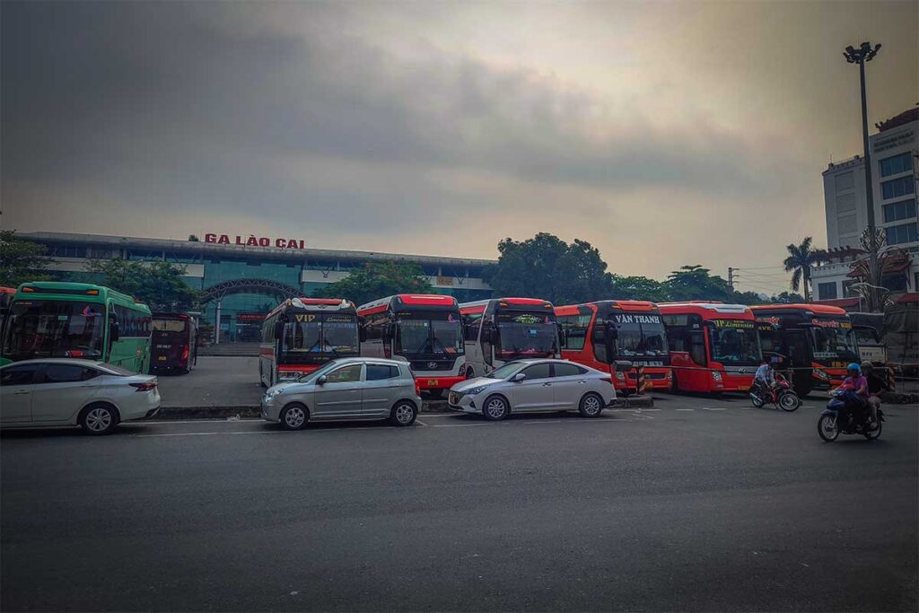Buses and taxis waiting outside Lao Cai Railway Station to bring arriving travellers to Sapa