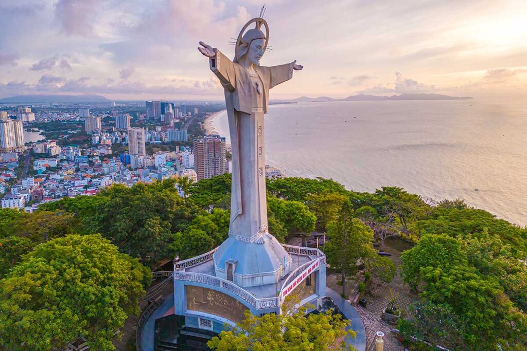 Christ The King Statue in Vung Tau with the city in the background and coastline