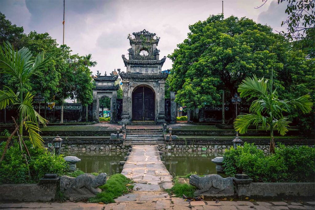 A stone path over a pond leading to the entrance gate of Chuong Temple in Hung Yen