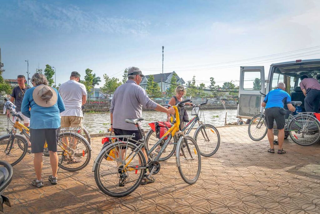 Tourists preparing for a guided cycling tour along canals in Soc Trang, Mekong Delta.