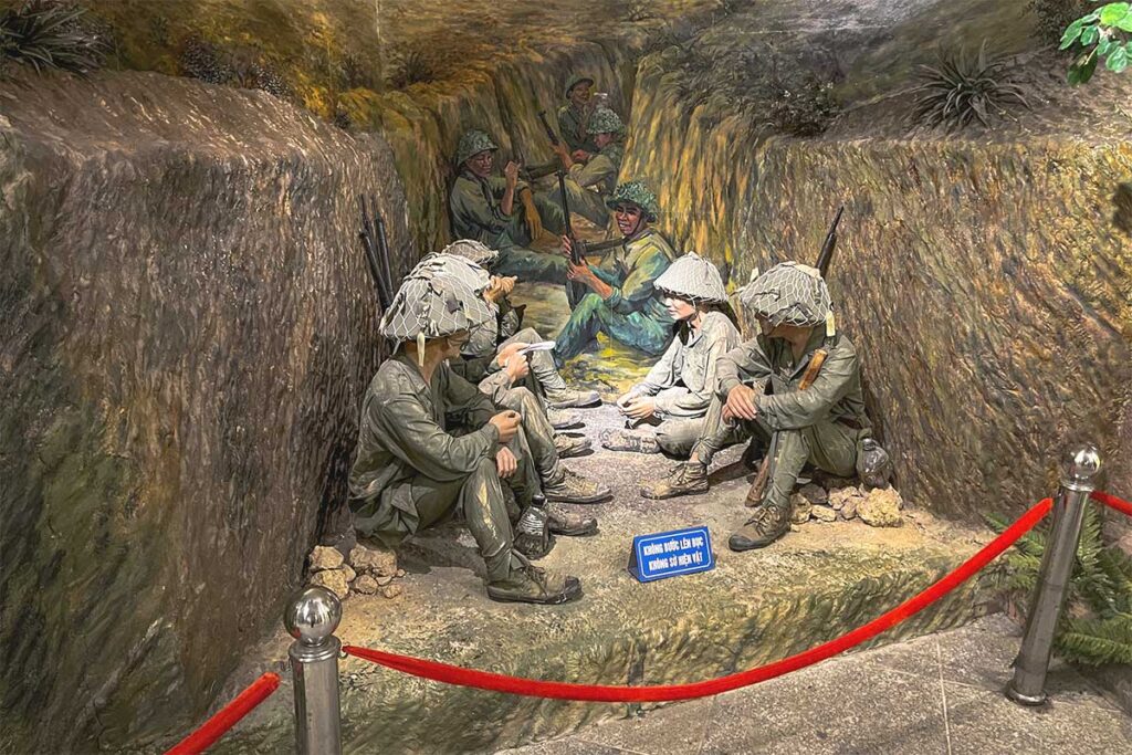 A museum exhibit featuring Vietnamese soldiers pushing and pulling an artillery gun, depicting the historical efforts during the battle.