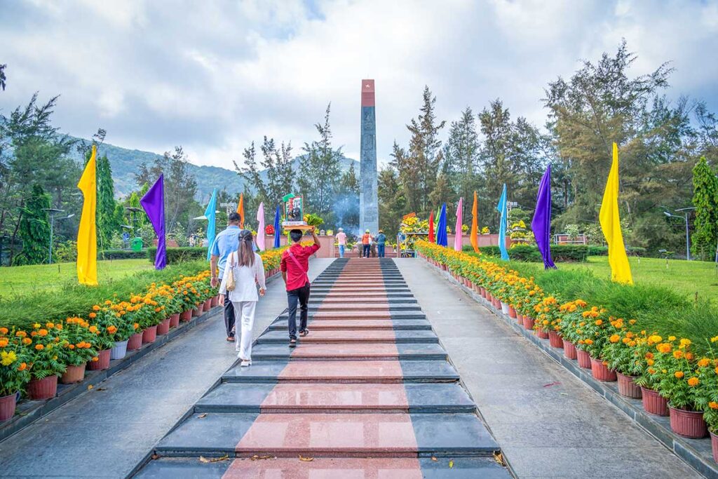 Vietnamese visitors walk towards a monument and altar inside Hang Duong Cemetery, a memorial site for Con Dao’s historical past.