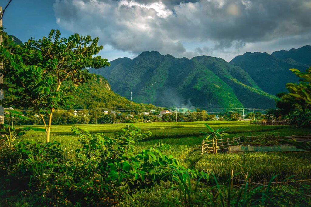 Countryside and mountains with ethnic village in background near Hoa Binh Lake