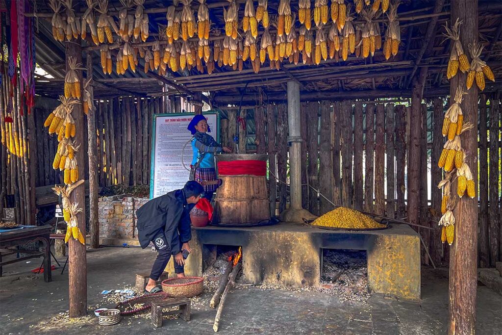 Ethnic woman cooking corn on traditional way at  Hoang A Tuong Palace