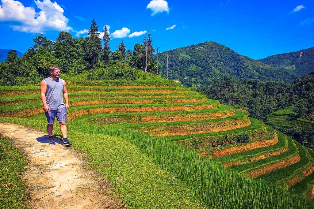 A tourist doing a trekking with views on the rice fields in Hoang Su Phi