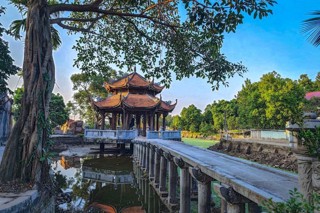 A stone bridge over a pond leading to a shrine in the middle of the water in Hung Yen