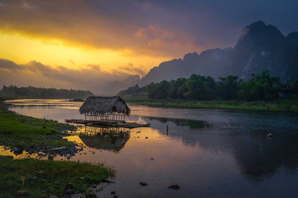 Sunset over a stream with mountains and forest in the background in Kim Boi District in Hoa Binh